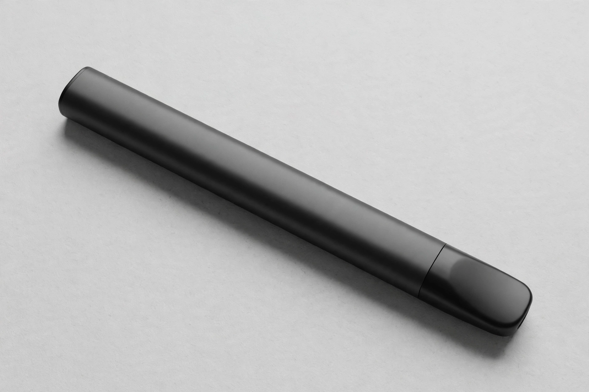 Slim matte black CBD vape pen lying on a light surface