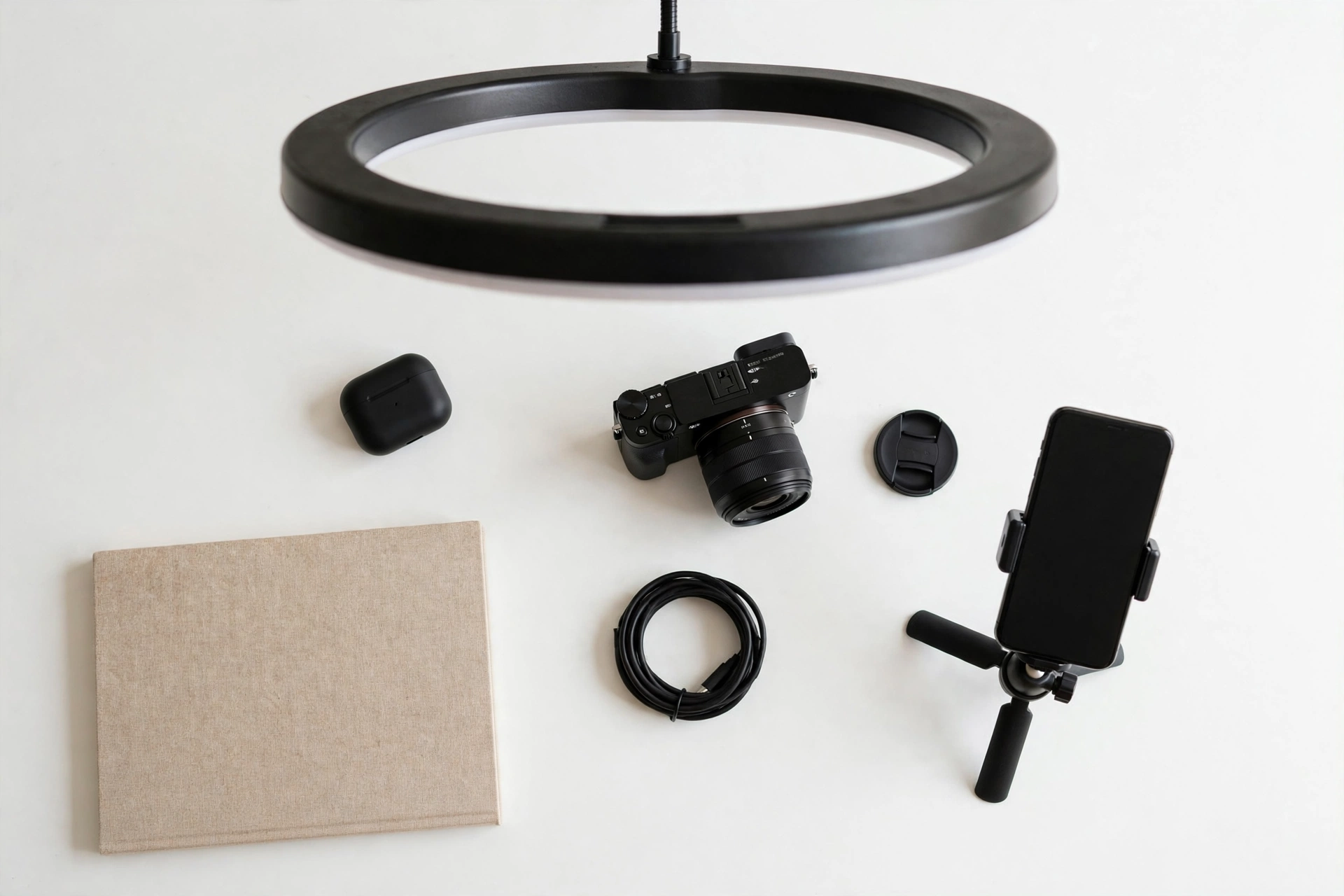 Content creator desk setup with ring light, smartphone tripod, and camera for filming TikTok videos