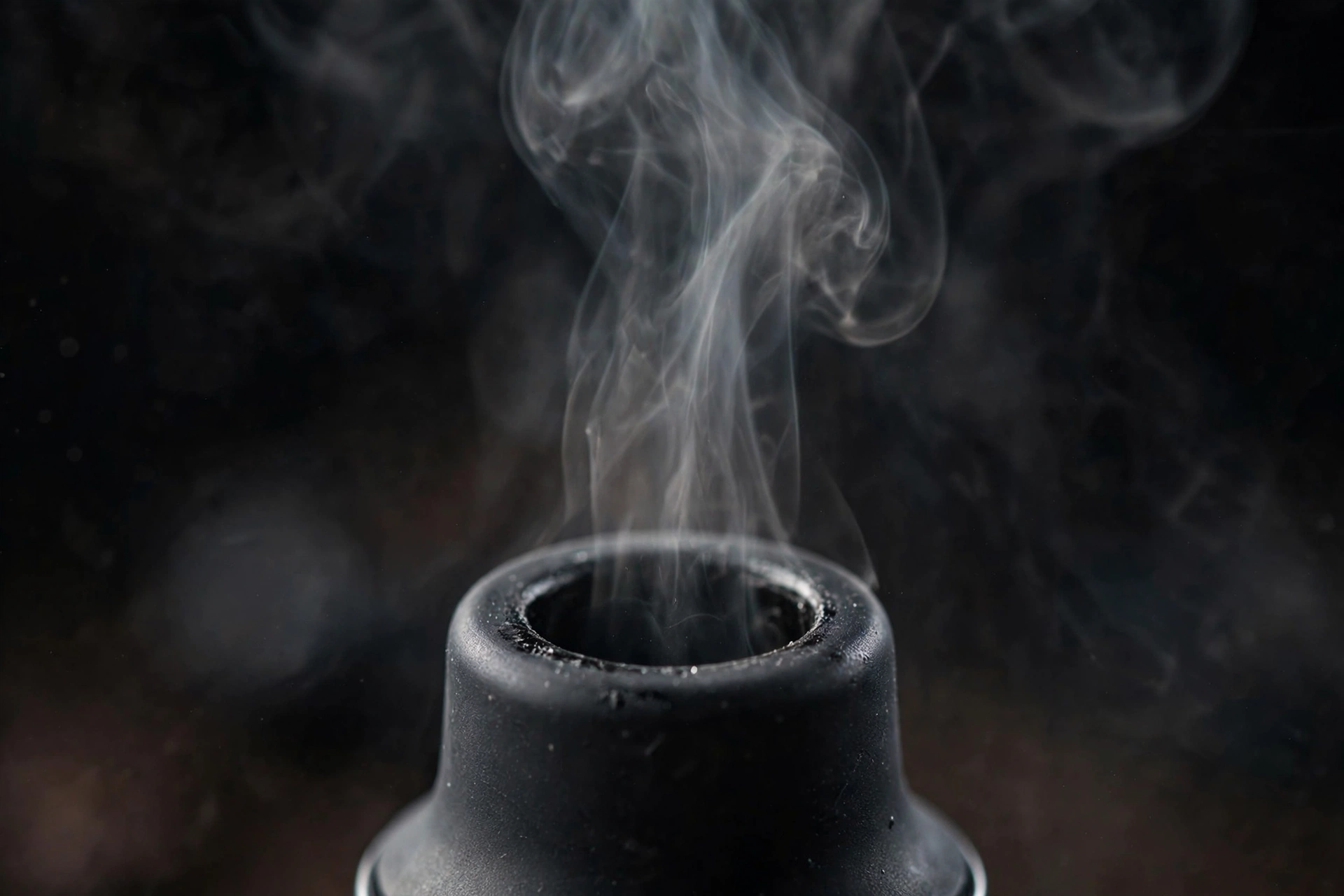 Close-up of a vape mouthpiece with a thin vapor trail illustrating the MTL draw style
